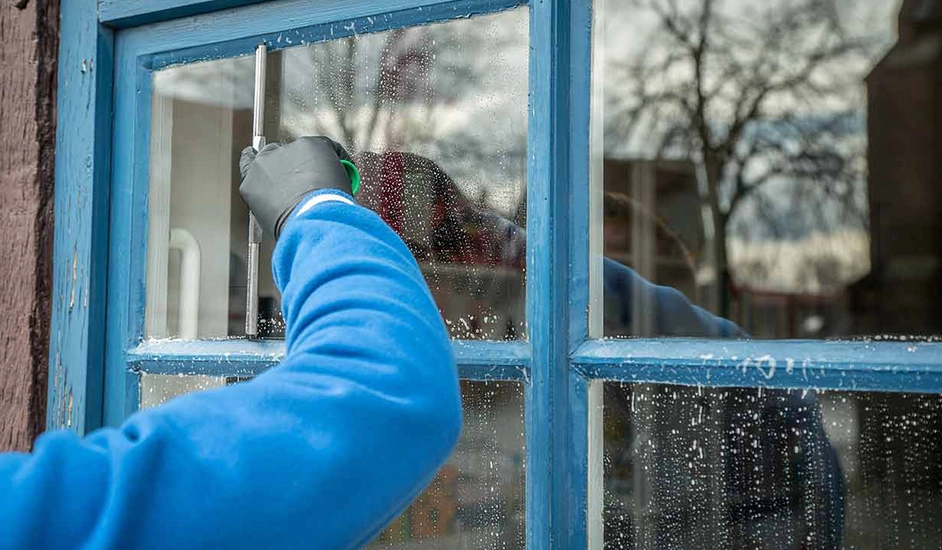 Fensterputzer reinigt eine Fensterscheibe
